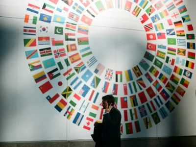 woman in black coat standing near round white red and blue wall