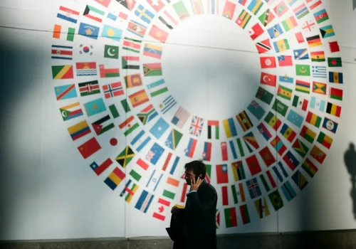 woman in black coat standing near round white red and blue wall