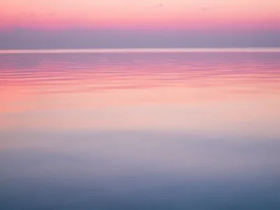 Pastel colored sky over calm ocean water