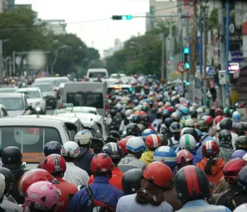 A large group of people riding motorcycles down a street
