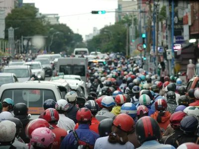A large group of people riding motorcycles down a street